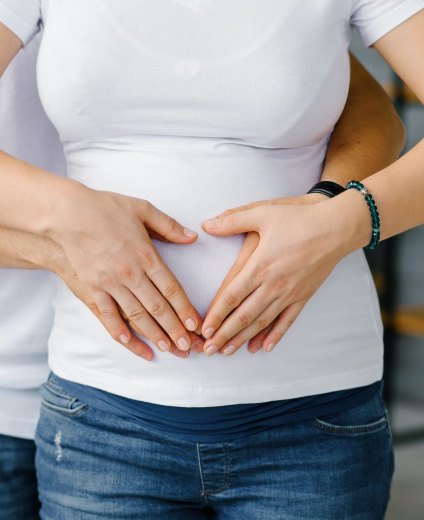 Hands touching a pregnant belly